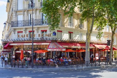 Paris, Fransa-21 Temmuz 2017: Paris, Fransa 'da güneşli bir yaz gününde oturan insanlar ve turistler ile kaldırım masaları ile tipik kafe Brasserie