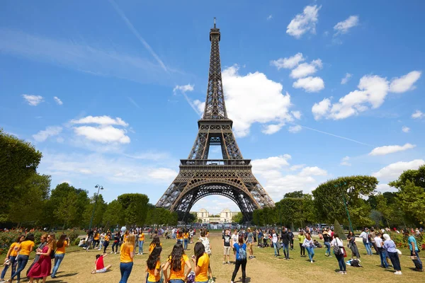 Eiffelturm in Paris und grüne Marswiese mit Menschen und Touristen an einem sonnigen Sommertag, blauer Himmel — Stockfoto