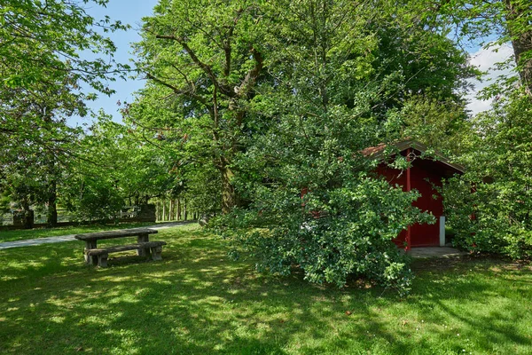Jardin avec table en pierre et petite maison rouge dans une journée ensoleillée d'été, Italie — Photo