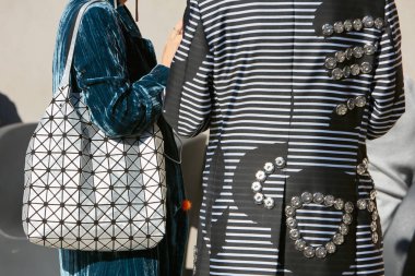 20 Eylül 2017 'de Milano' da Alberto Zambelli moda defilesinden önce siyah beyaz çizgili ceketli ve gümüş renkli geometrik çantalı bir kadın..