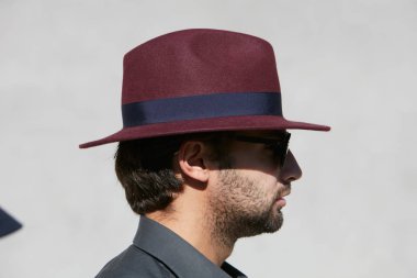 Alberto Zambelli defilesinden önce güneşli bir günde koyu kırmızı şapkalı adam, Milano Moda Haftası sokak stili 20 Eylül 2017'de Milano'da.