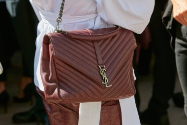 20 Eylül 2017 'de Milano' da Alberto Zambelli moda defilesinden önce Yves Saint Laurent kahverengi deri çantalı kadın..