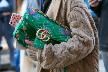 Woman with beige wool sweater and Gucci bag with floral design chain before Max Mara fashion show, Milan Fashion Week street style on September 21, 2017 in Milan. clipart