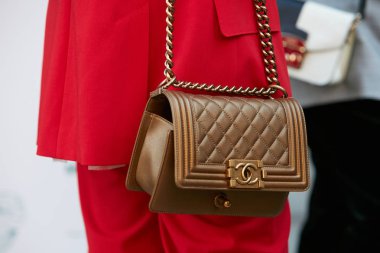 Altın çantalı ve kırmızı elbiseli kadın Max Mara moda defilesinden önce, Milan Moda Haftası tarzı 21 Eylül 2017 'de Milano' da.