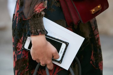 Luisa Beccaria defilesinden önce siyah ve kırmızı çiçekli iPhone 'lu kadın, Milan Moda Haftası tarzı 21 Eylül 2017' de Milano 'da.