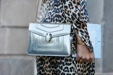 Gümüş rengi Bulgari çantalı kadın, altın bilezikler ve leopar desenli elbise Luisa Beccaria defilesinden önce, Milan Moda Haftası tarzı 21 Eylül 2017 'de Milano' da.