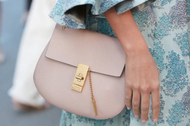 Luisa Beccaria defilesinden önce pembe deri çantalı ve mavi çiçekli bir kadın, Milan Moda Haftası 21 Eylül 2017 'de Milano' da.