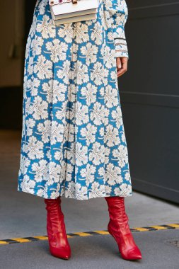 Çiçek desenli ve kırmızı ayakkabılı beyaz ve mavi elbiseli kadın Fendi defilesinden önce, Milan Moda Haftası 21 Eylül 2017 'de Milano' da.