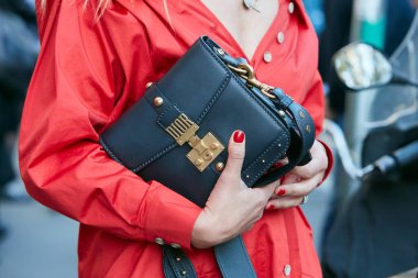 Prada defilesinden önce siyah deri çantalı ve kırmızı ceketli kadın, Milan Moda Haftası 21 Eylül 2017 'de Milano' da.