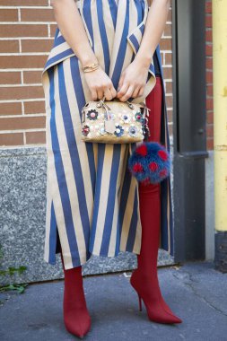 Fendi desenli Fendi çantalı ve yüksek topuklu kırmızı çizmeli kadın Fendi defilesinden önce, Milan Moda Haftası 21 Eylül 2017 'de Milano' da.