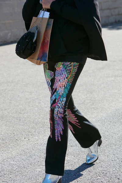 Kvinna med färgglada paljett vinge dekoration på svarta byxor och silver stövlar innan Alberto Zambelli modevisning, Milan Fashion Week street style den 20 september 2017 i Milano. — Stockfoto