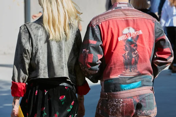 Чоловік і жінка з червоними джинсами прикрашені куртки і чорна спідниця з трояндами перед Альберто Zambelli показ мод, Мілан тиждень моди вулиці стиль на 20 вересня, 2017 в Мілані. — стокове фото