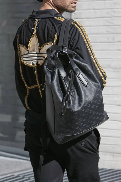 Man met zwarte Louis Vuitton rugzak en zwarte en gouden adidas jas voor Alberto Zambelli fashion show, Milan Fashion week Street Style op september 20, 2017 in Milaan. — Stockfoto