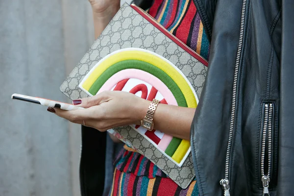 在2017年9月21日于米兰举行的米兰时装周街头时装秀之前，佩带Panthere de Cartier金手表和Gucci Love手提包看着智能手机的女人. — 图库照片
