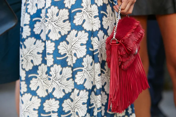 Vrouw met blauwe en witte bladeren design rok en rode bontzak met franjes voor Fendi modeshow, Milaan Fashion Week straatstijl op 21 september 2017 in Milaan. — Stockfoto