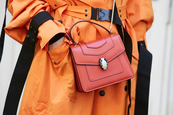 Vrouw met rode Bulgari tas en oranje trench jas voor Fendi modeshow, Milaan Fashion Week straatstijl op 21 september 2017 in Milaan. — Stockfoto