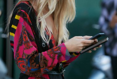22 Eylül 2017 'de Milan' da Giorgio Armani moda defilesinden önce iki akıllı telefonu ve pembe pembesi olan kadın..