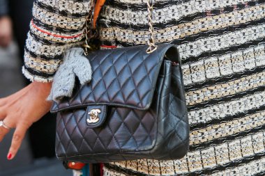 Woman with black leather Chanel bag before Giorgio Armani fashion show, Milan Fashion Week street style on September 22, 2017 in Milan.