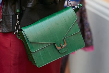 Spor defilesinden önce yeşil deri çantalı ve kırmızı etekli kadın, Milan Moda Haftası 22 Eylül 2017 'de Milano' da.