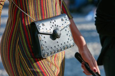 22 Eylül 2017 'de Milano' da Marco de Vincenzo moda defilesinden önce Bulgar çantalı, sarı, kırmızı ve yeşil çizgili elbiseli bir kadın..