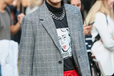 Marco de Vincenzo defilesinden önce çizgi roman ve zincir kolyeli gri ceketli ve siyah gömlekli adam, Milano Moda Haftası sokak stili 22 Eylül 2017'de Milano'da.