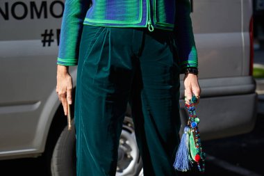 Giorgio Armani defilesinden önce yeşil kadife pantolonlu ve mücevher çantalı kadın, Milan Moda Haftası 22 Eylül 2017 'de Milano' da.