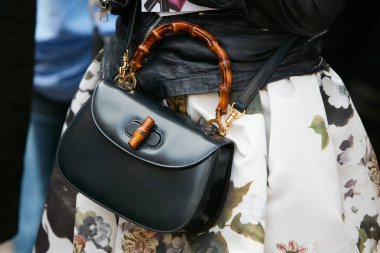 23 Eylül 2017 'de Milan Moda Haftası' nda Antonio Marras defilesinden önce bambu saplı ve beyaz çiçekli siyah deri çantalı kadın..