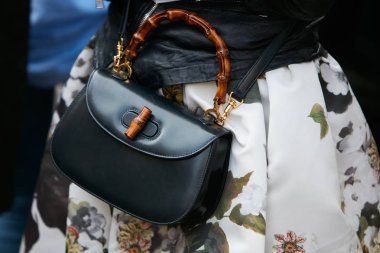 23 Eylül 2017 'de Milan Moda Haftası' nda Antonio Marras defilesinden önce bambu saplı ve beyaz çiçekli siyah deri çantalı kadın..