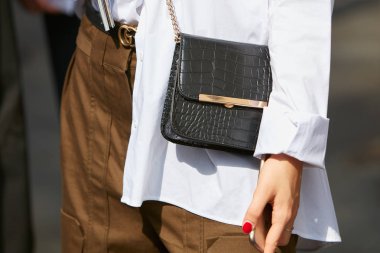 Siyah timsah derisi ceketli, kahverengi pantolonlu ve Gucci kemerli kadın Antonio Marras moda defilesinden önce, Milan Moda Haftası tarzı 23 Eylül 2017 'de Milano' da.