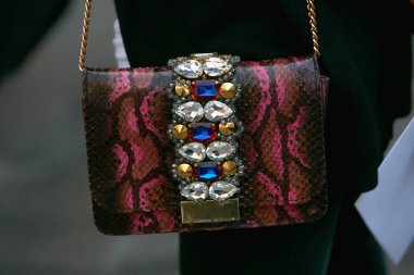 Blumarine moda defilesinden önce koyu kırmızı deri çantalı ve mücevherli kadın, Milan Moda Haftası tarzı 23 Eylül 2017, Milano.