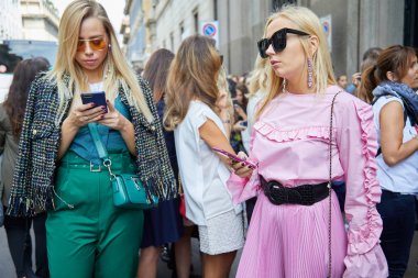 23 Eylül 2017 'de Milan Moda Haftası' nda Ermanno Scervino defilesinden önce akıllı telefona bakan yeşil ve pembe elbiseli kadınlar..