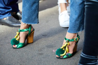 23 Eylül 2017 'de Milan' da, Ermanno Scervino moda defilesinden önce yeşil topuklu, açık ayakkabılı ve muzlu bir kadın..