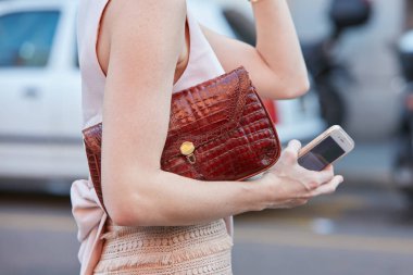 Koyu kırmızı deri çantalı ve pembe elbiseli kadın Trussardi moda defilesinden önce, Milan Moda Haftası tarzı 24 Eylül 2017 'de Milano' da.