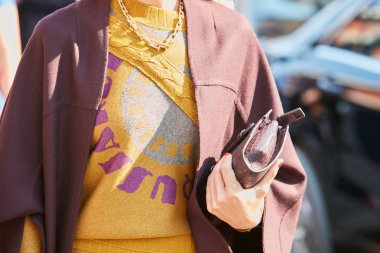 Trussardi moda defilesinden önce kahverengi pelerinli ve sarı kazaklı kadın, Milan Moda Haftası tarzı 24 Eylül 2017, Milano.