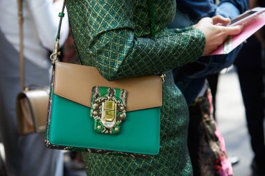 Dolce ve Gabbana marka deri çantalı, Dolce ve Gabbana moda defilesinden önce giyinen kadın, Milan Moda Haftası tarzı 24 Eylül 2017, Milano.
