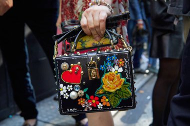 Dolce ve Gabbana defilesinden önce çiçek desenli siyah Dolce ve Gabbana çantalı kadın, Milan Moda Haftası tarzı 24 Eylül 2017, Milano.