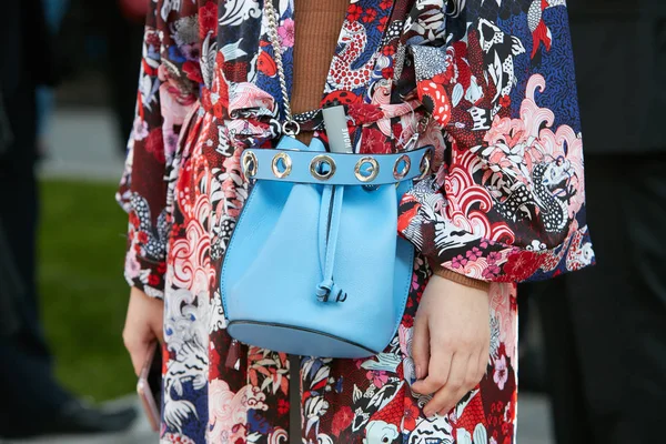 Mujer con bolso de cuero azul claro y vestido decorado floral rojo, blanco y azul antes del desfile de moda Giorgio Armani, Milan Fashion Week street style on septiembre 22, 2017 in Milan . — Foto de Stock