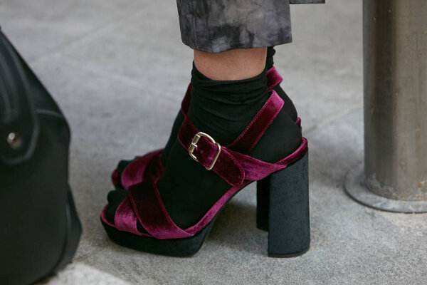 Женщина в пурпурной бархатной обуви на высоком каблуке перед показом мод Джорджио Армани, уличный стиль Недели Моды в Милане 22 сентября 2017 года
.