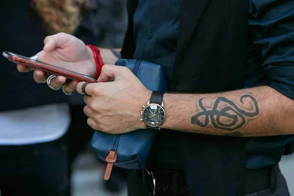 Hombre con Emporio Armani reloj comprobar teléfono inteligente antes de Giorgio Armani desfile de moda, Milán Fashion Week street style en septiembre 22, 2017 en Milán . — Foto de Stock