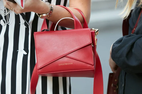 Perempuan dengan tas kulit Emporio Armani merah dan pakaian bergaris-garis hitam dan putih sebelum peragaan busana Giorgio Armani, Milan Fashion Week gaya jalanan pada 22 September 2017 di Milan . — Stok Foto