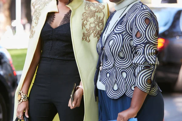 Giorgio Armani defilesinden önce sarı-mavi ve beyaz desenli iki kadın karmaşık ceket, Milano Moda Haftası sokak stili 22 Eylül 2017'de Milano'da.