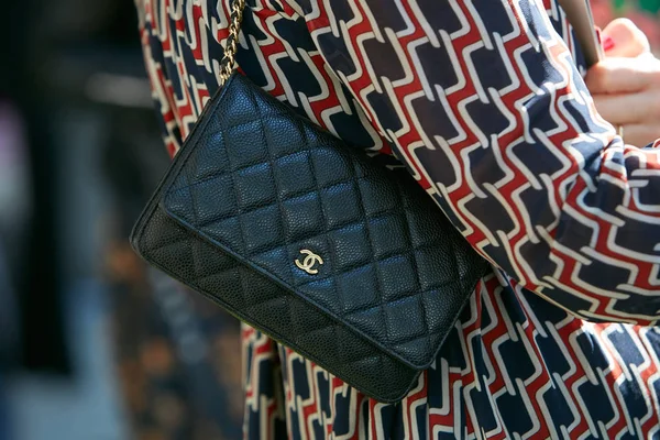 Mujer con pequeño bolso de cuero negro Chanel con logo dorado antes del desfile de moda Giorgio Armani, Milan Fashion Week street style on septiembre 22, 2017 in Milan . —  Fotos de Stock