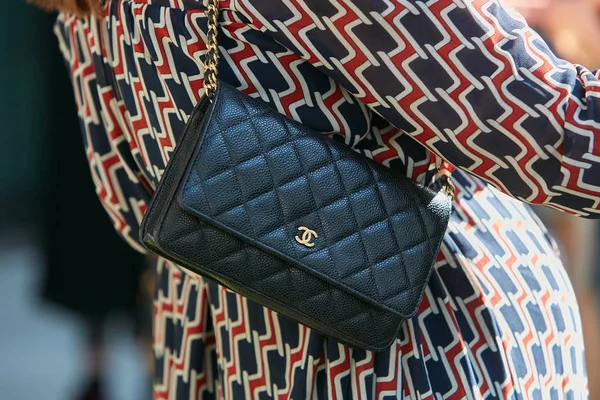 Giorgio Armani defilesinden önce küçük Chanel siyah deri çantalı ve kırmızı ve mavi elbiseli kadın, Milan Moda Haftası 22 Eylül 2017 'de Milano' da.