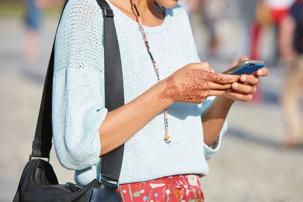 Mujer con tatuaje de henna en la mano mirando el teléfono inteligente antes del desfile de moda Marco de Vincenzo, Milan Fashion Week street style on septiembre 22, 2017 in Milan . —  Fotos de Stock