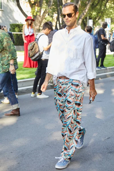 ジョルジオ・アルマーニのファッションショーの前に白いシャツとカラフルな幾何学的なデザインの柔らかいズボンを持つ男、ミラノで9月22、2017年9月22日にミラノのファッションウィークストリートスタイル. — ストック写真
