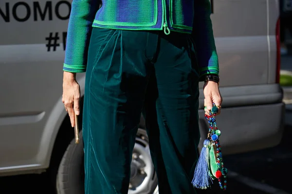 Женщина в зеленых бархатных брюках и сумке с драгоценностями перед показом мод Джорджио Армани, стиль улицы Недели моды в Милане 22 сентября 2017 года в Милане . — стоковое фото