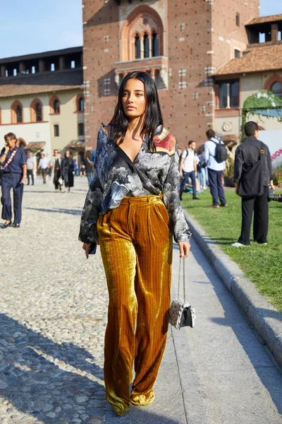 Женщина с золотыми бархатными брюками в солнечном свете перед показом мод Marco de Vincenzo, стиль улицы Milan Fashion Week 22 сентября 2017 года в Милане . — стоковое фото