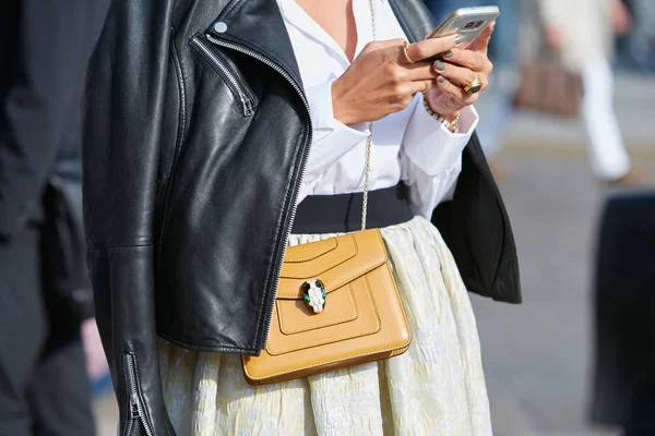 Mujer con bolso Bulgari de cuero amarillo mirando el teléfono inteligente antes del desfile de moda Gabriele Colangelo, Milan Fashion Week street style on septiembre 23, 2017 in Milan . — Foto de Stock