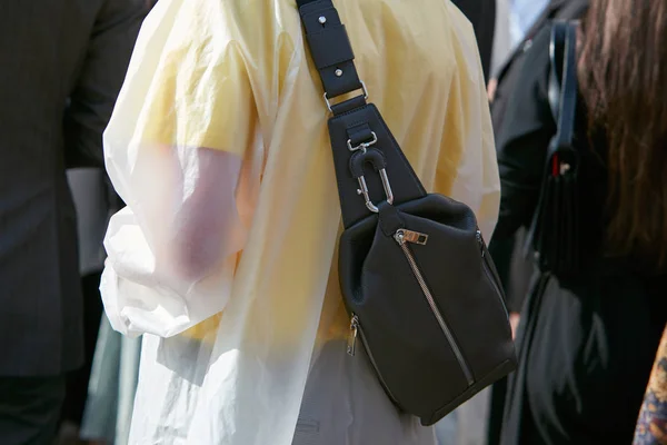 Женщина с черной кожаной сумкой и прозрачным плащом перед показом мод Габриэле Коланжело, уличный стиль Миланской недели моды 23 сентября 2017 года в Милане . — стоковое фото