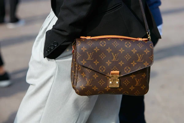 Женщина с сумкой Louis Vuitton в черной куртке и серых брюках перед показом мод Габриэле Коланжело, уличный стиль Недели Моды в Милане 23 сентября 2017 года . — стоковое фото